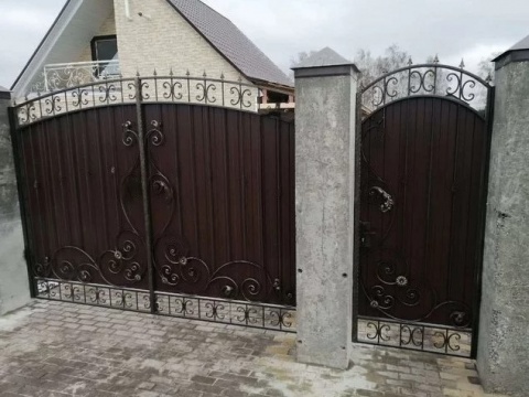 Кованые ворота черные с коваными элементами сверху и калиткой для частного дома